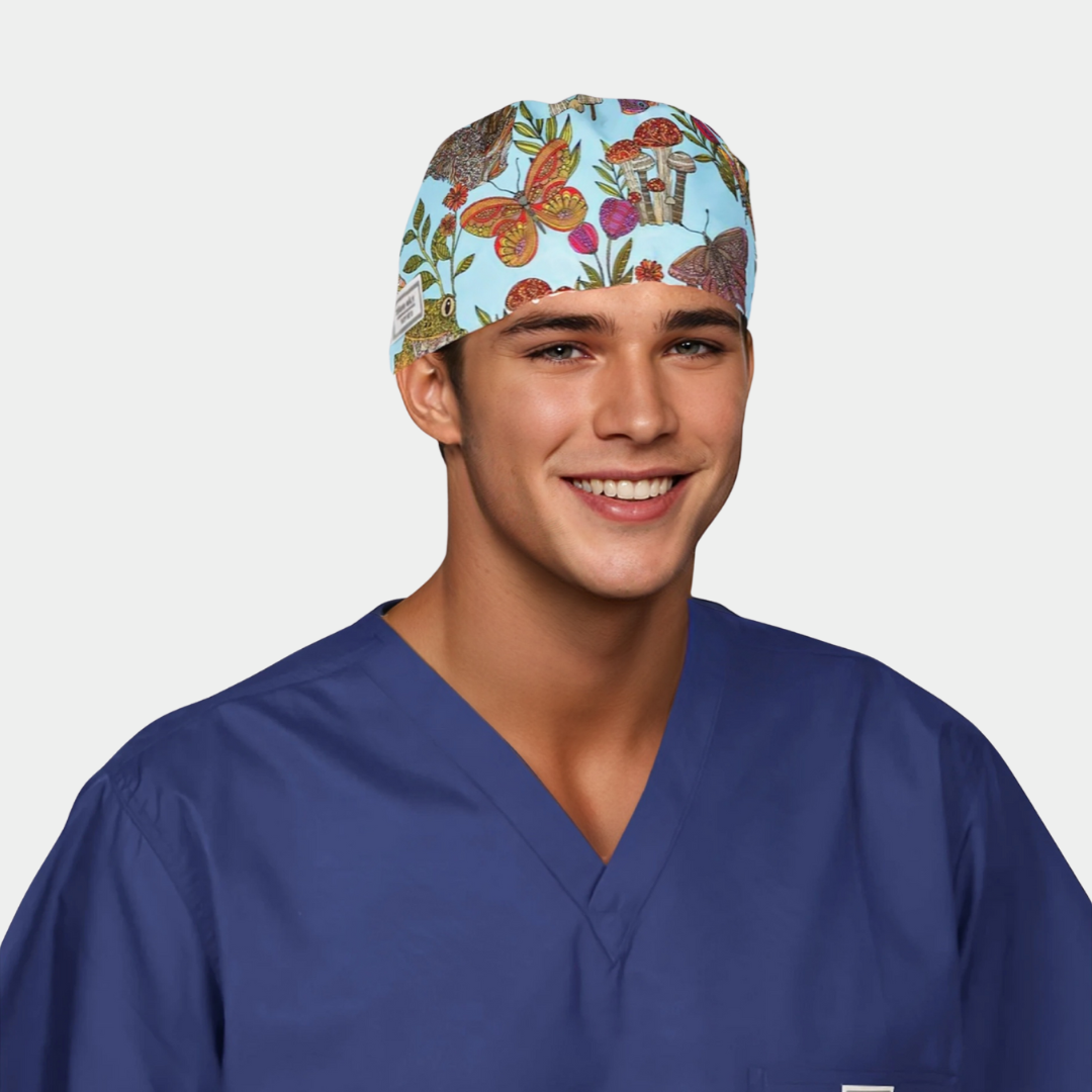 man wearing a navy blue scrub top and a light blue mens scrub hat with butterflies, plants and flowers