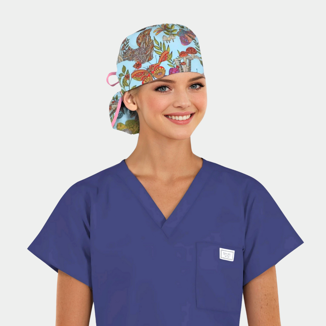 woman wearing a navy scrub top and a ponytail scrub cap that is light blue with flowers, butterflies and plants on it.