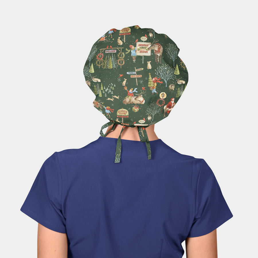 woman wearing a navy blue scrub top and a bouffant scrub hat that is christmas themed with santas and reindeer