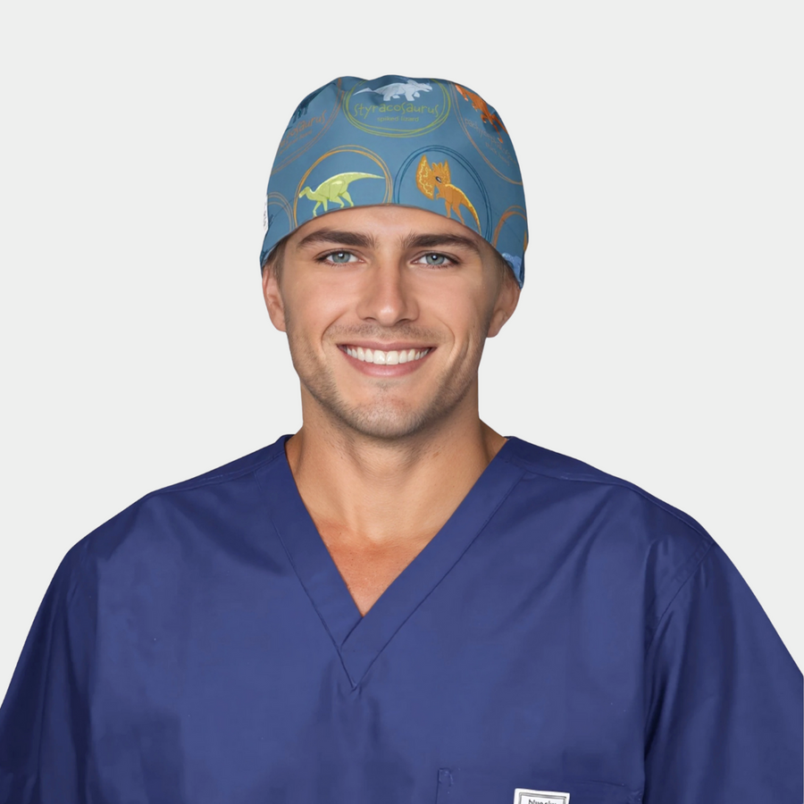 man wearing a navy blue scrub top and a blue scrub hat with dinosaurs on it on a white background