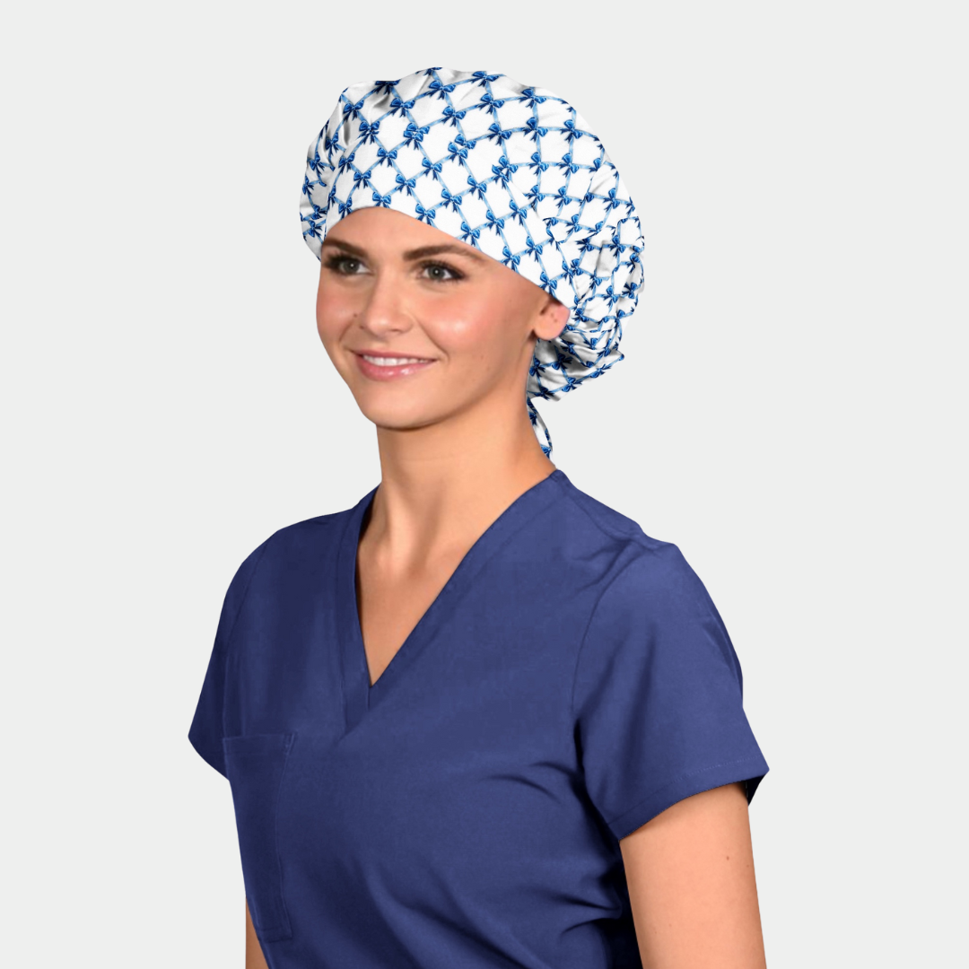 Woman wearing a blue scrub top and patterned headscarf on a white background