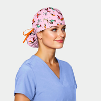 woman wearing a pink ponytail scrub cap with dogs on it and a light blue scrub top on a white background