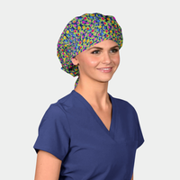 Person wearing a colorful patterned bouffant scrub cap and blue scrub top on a white background