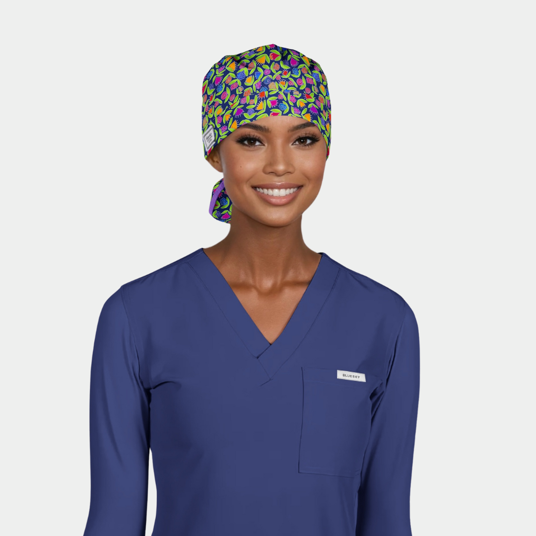 woman wearing a blue scrub top and a floral scrub cap on a white background