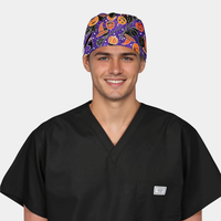 Man wearing a black scrub top and Halloween-themed scrub cap on a white background