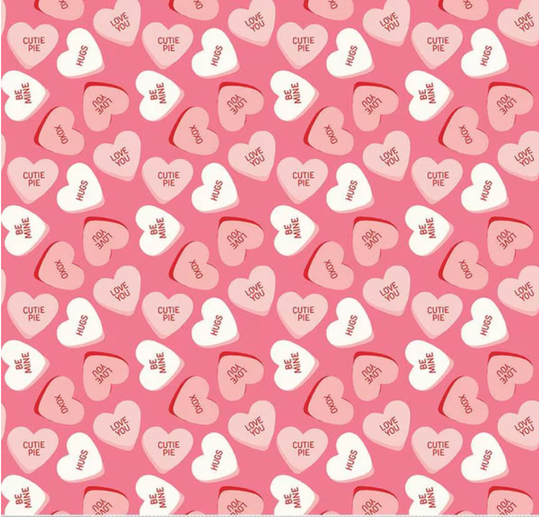 Pattern of heart-shaped candy with text on a pink background