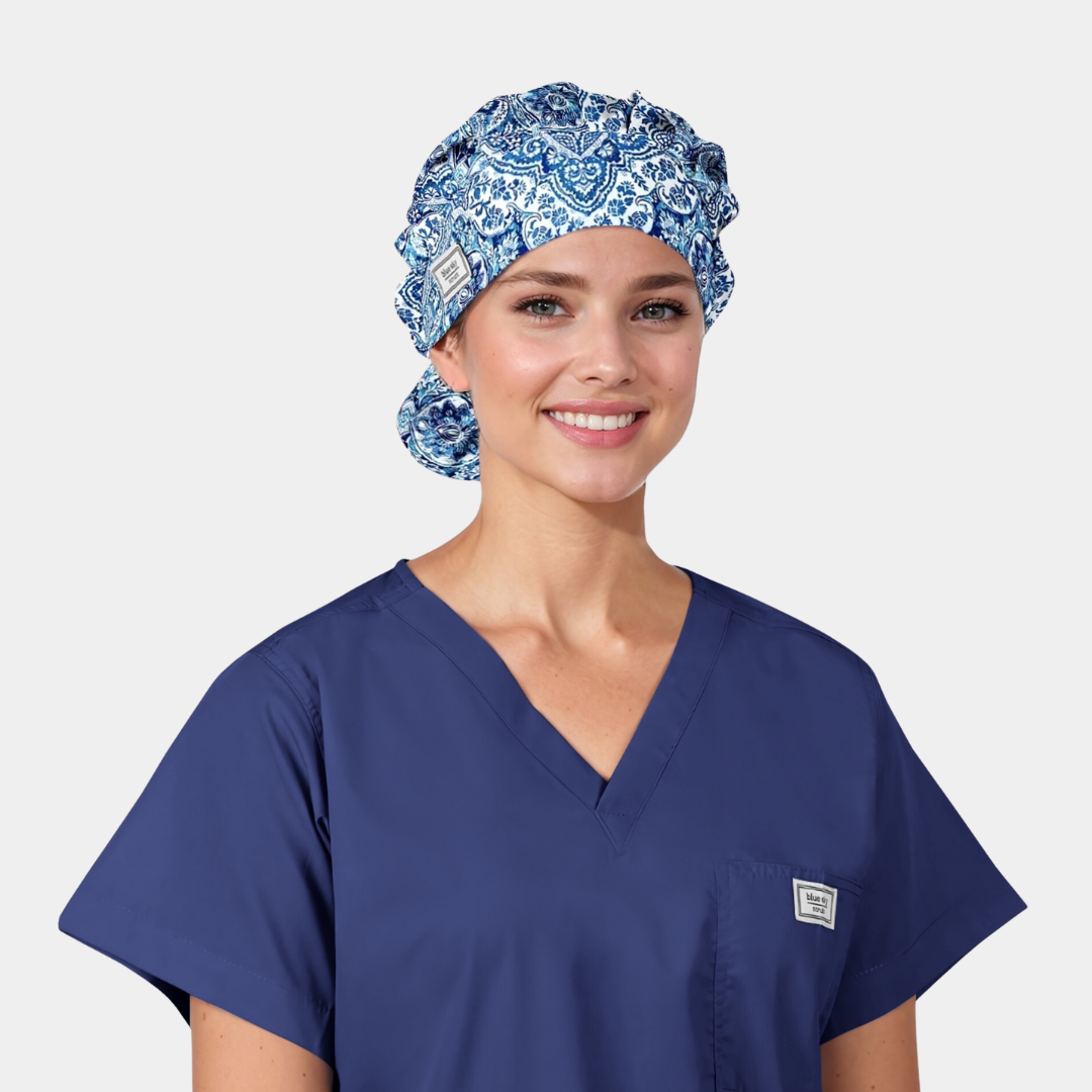 Person wearing a blue scrub top and matching scrub cap on a white background