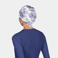 woman wearing a white and blue scrub cap and a navy blue scrub top