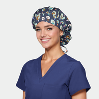 Woman wearing a navy blue scrub top and patterned scrub cap on a light gray background