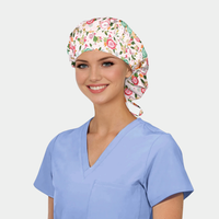 Woman wearing a floral bouffant scrub cap and light blue scrub top on a white background