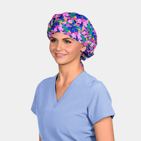 woman wearing a floral bouffant scrub hat with a light blue scrub top on a white background
