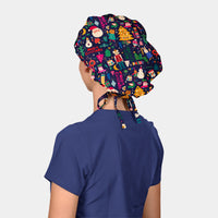 Person wearing a colorful Christmas-themed bouffant scrub cap and a navy blue scrub top