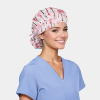 woman wearing a bouffant scrub hat with pink guitars on it and a light blue scrub top on a white background