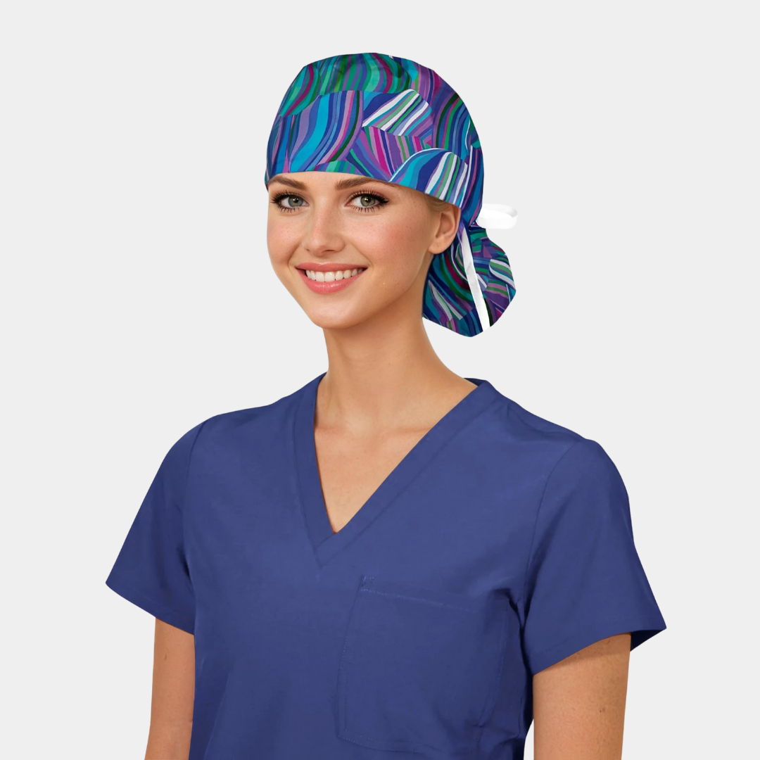 Woman wearing a colorful scrub cap and blue scrub top on a light gray background