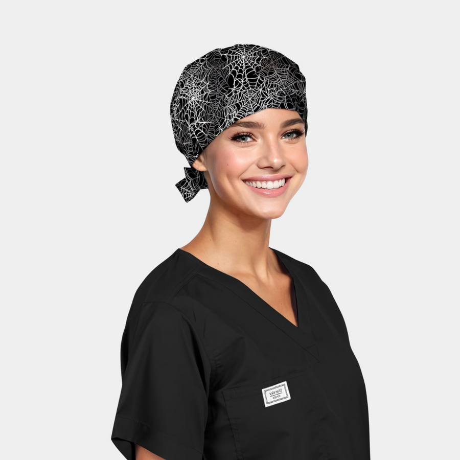 a woman wearing a black scrub top and a halloween scrub hat that is black with white spiderwebs